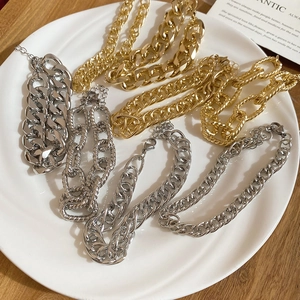Close-up of assorted gold and silver metal chain bracelets with polished link textures