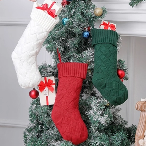 Large 46cm knitted Christmas stockings in red, white and green hanging on a tree