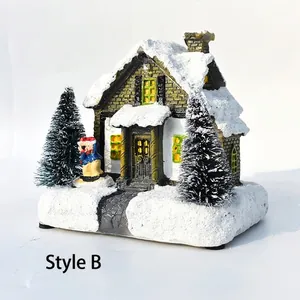 Close-up of resin Christmas snow house miniature with skiing figure and flocked trees
