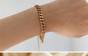 Gros plan détaillé d'un bracelet gourmette doré avec une chaîne d'extension réglable au poignet