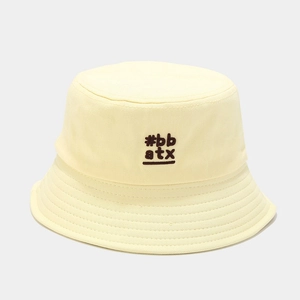 Detail of cream yellow cotton bucket hat featuring brown #bb atx embroidered lettering