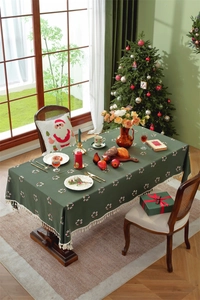 Detail of green Christmas tablecloth with embroidered wreaths and elegant tassel edges