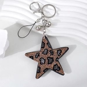 Close-up of leopard print star keychain with rhinestones, silver clasp and small bells