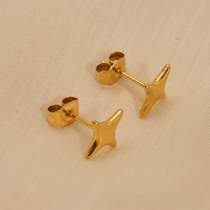 Detailed side view of 18k gold-plated stainless steel star studs on fabric