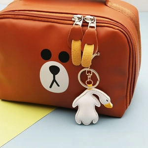 Detailaufnahme der braunen PU-Ledertasche mit Bärengesicht und weißem Gänseanhänger