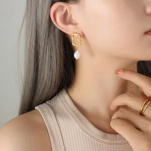 Baroque irregular gold square earrings with drop pearl pendant shown on a female model