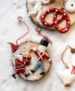 Set of painted Christmas ornaments including Santa and angel on a rustic wood slice