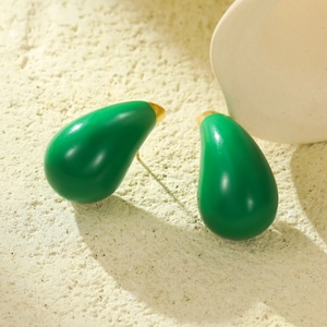 Fashionable green teardrop enamel stud earrings with gold trim on textured stone background
