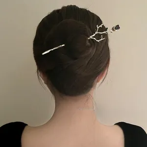 Detailed view of a vintage gothic rose branch hair pin elegantly styled in a bun