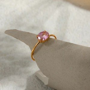 Macro view of a 18k gold stainless steel ring with a pink oval zircon on stone