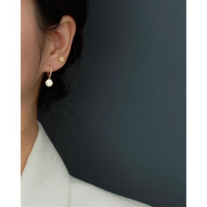 Close-up of S925 sterling silver floral stud and smile pendant earring on model ear