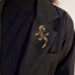 Lizard crystal brooch with colorful rhinestones on a gold base worn on a black blazer