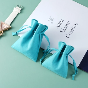 Teal faux suede drawstring pouch for jewelry and watches in two sizes on a desk