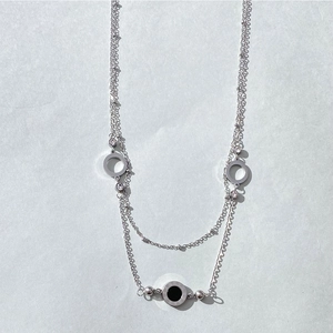 Close-up of double-layer stainless steel necklace with Roman numerals and zircon pendant