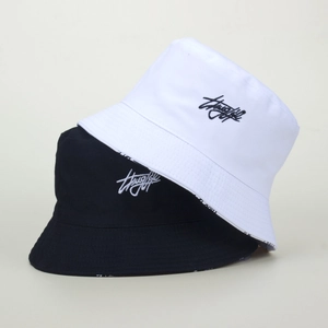 Embroidered bucket hats in black and white featuring cursive script on cotton fabric