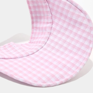 Detailed view of pink and white gingham pattern fabric on the sun hat's wide brim