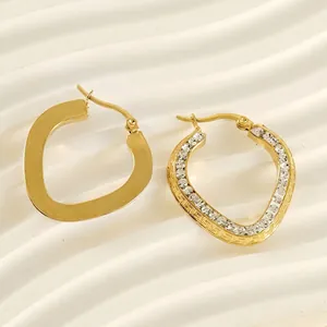 Gold-plated heart-shaped earrings with rhinestones and Greek key pattern on a white base