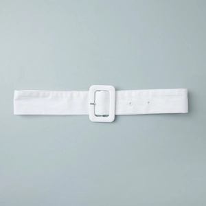 Détail d'une large ceinture blanche avec boucle rectangulaire gainée de tissu