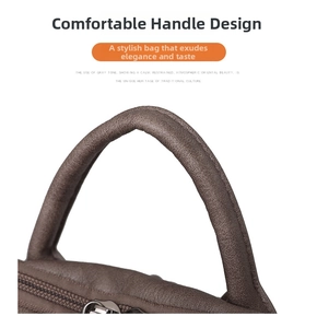 Detail of comfortable rounded top handles and smooth zipper on vintage leather backpack