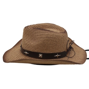 Detail eines braunen Stroh-Cowboyhuts mit Lederband und silbernen Sternnieten-Verzierungen