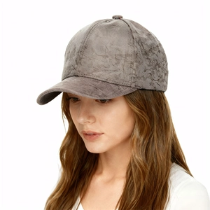 Close-up of a woman wearing a dark brown faux suede baseball cap in a classic six-panel design