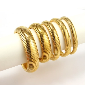 Detail view of five gold titanium steel snake bone bangles on a white column display