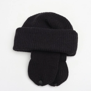 Detail of black ribbed knit earflap hat with secure snap buttons and thick wool texture