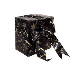Elegant black and gold Christmas wrapping paper with snowflake and reindeer patterns