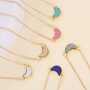 Multiple gold-plated necklaces with glitter-filled acrylic moon pendants in various colors