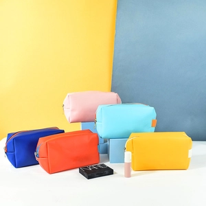 Detailed view of colorful PU leather cosmetic bags in various pastel shades and textures