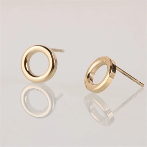 Macro shot of minimalist gold hollow circular stud earrings with smooth reflective finish