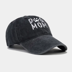 Détail de la broderie blanche DOG MOM sur le côté d'une casquette de baseball en coton noir