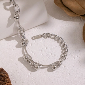 Detail shot of silver stainless steel chain bracelet with metallic sphere ornaments
