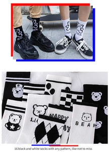 Detail of 16-pack black and white crew socks with checkered and cartoon bear patterns