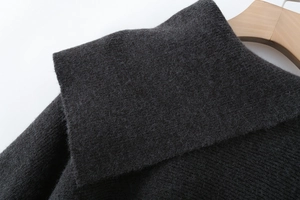 Detailed macro view of dark grey knit fabric texture on asymmetric cape collar