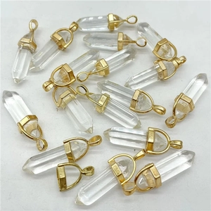 Macro shot of hexagonal crystal point pendants with polished gold metal caps