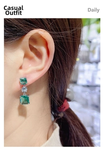 Close-up of elegant emerald-cut green cubic zirconia earrings in polished silver finish