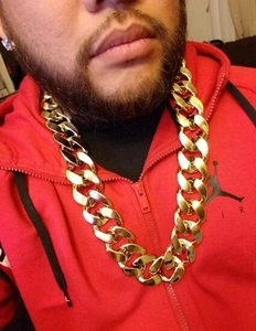 Detailopname van de grote grove gouden Cubaanse schakelketting gedragen door het model