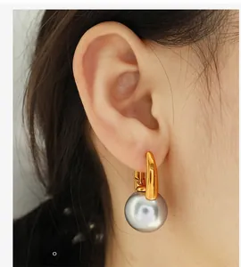 Close-up of elegant gold pearl drop earrings worn by a model for a stylish look