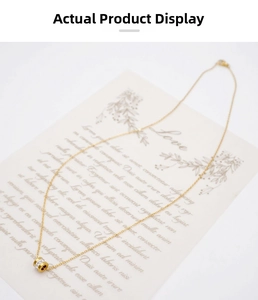 Detailed view of golden titanium necklace with a cylinder pendant and inlaid crystals