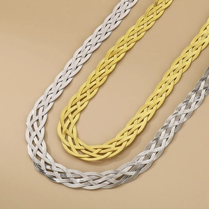 Detailed close-up of triple-strand woven flat snake bone chain in gold and silver steel