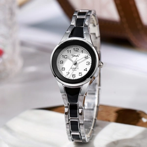 Macro detail of silver and black steel band quartz watch on marble surface