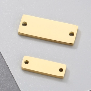 Detailed view of two polished golden stainless steel rectangle charms with dual holes