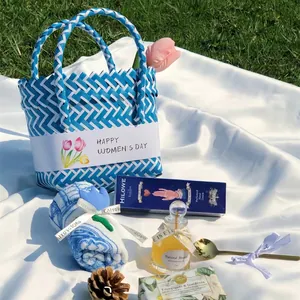 Woven blue and white gift basket detail with hand cream, honey, and floral towel set