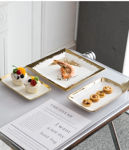Detail of luxury ceramic plate set with brushed gold rims for dining or jewelry display