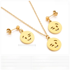 Detailed view of gold stainless steel necklace and earring set with winking smiley face