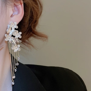 Detail of silver floral tassel earrings with multilayered petals and crystal drop chains