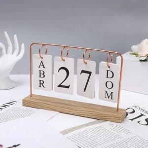 Detail of Nordic wooden calendar featuring rose gold metal frame and flip cards on wood base