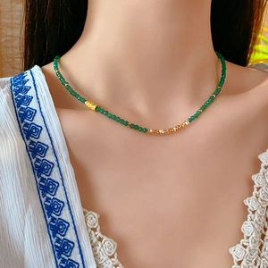 Détail du collier pour femmes avec perles vertes et accents métalliques dorés