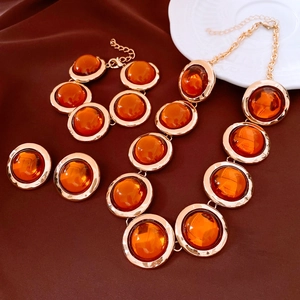 Dettaglio di un set di gioielli vintage in resina ambra con collana e orecchini dorati